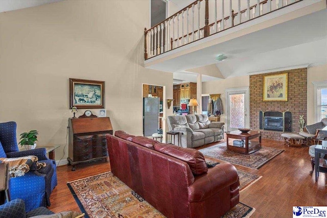 2284 Syracuse Community Rd, Darlington, SC 29532 - living area featuring wood finished floors, high vaulted ceiling, a brick fireplace, and baseboards