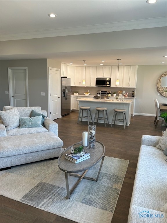 living room featuring ornamental molding and dark hardwood / wood-style floors