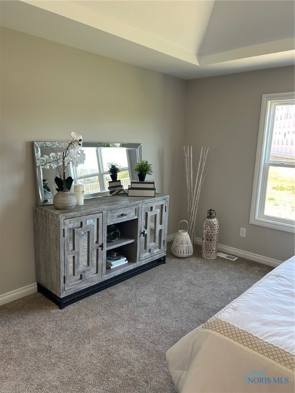 bedroom with lofted ceiling, dark carpet, and multiple windows