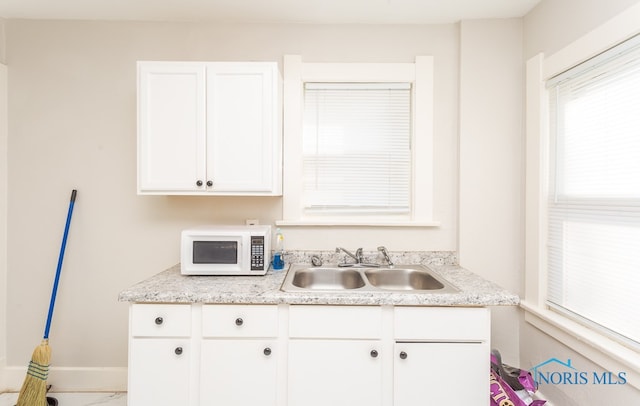 kitchen with white cabinetry and sink