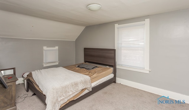 bedroom featuring light colored carpet and lofted ceiling