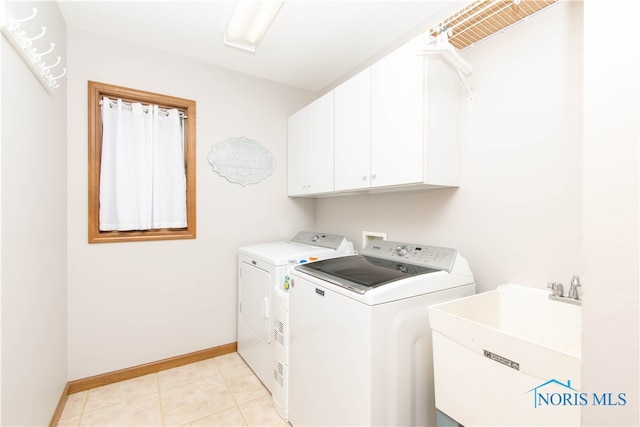 laundry room with light tile floors, cabinets, independent washer and dryer, and sink