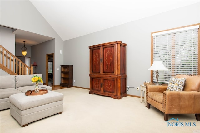 carpeted living room with high vaulted ceiling