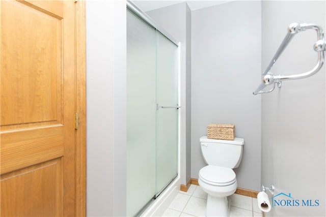 bathroom featuring walk in shower, tile flooring, and toilet