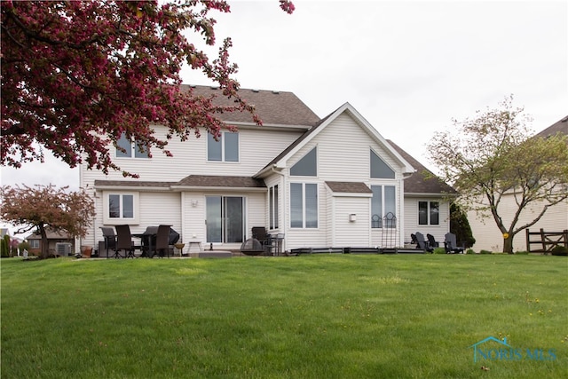 rear view of property with a lawn, central AC, and a patio area