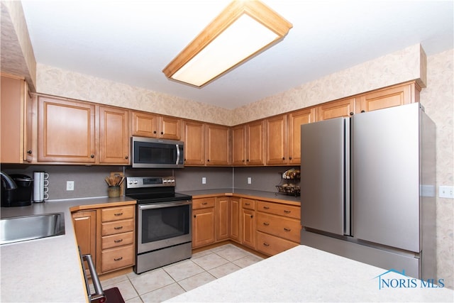 kitchen featuring light tile floors, sink, and stainless steel appliances