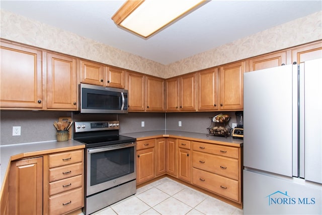 kitchen featuring light tile floors and appliances with stainless steel finishes