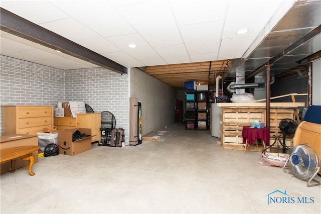 basement featuring brick wall and gas water heater