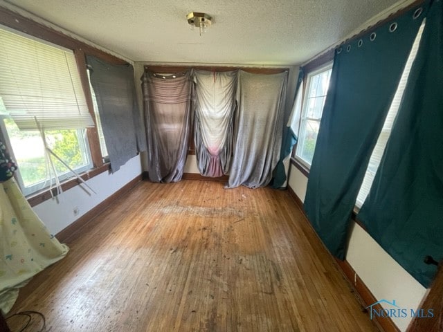 empty room featuring a textured ceiling and dark hardwood / wood-style flooring