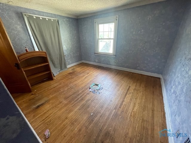 unfurnished room featuring a textured ceiling and hardwood / wood-style flooring