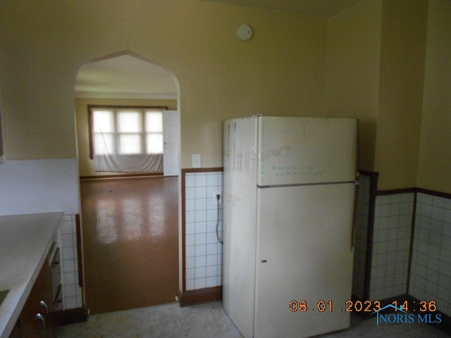 kitchen featuring tile walls and white refrigerator