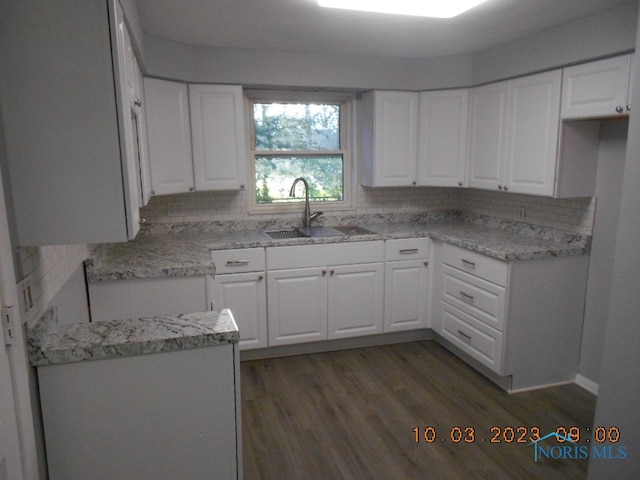 kitchen with white cabinets, sink, and tasteful backsplash