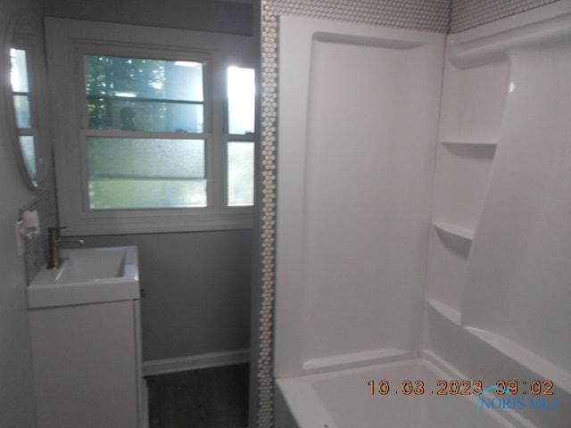 bathroom with shower / bathing tub combination, vanity, and a wealth of natural light