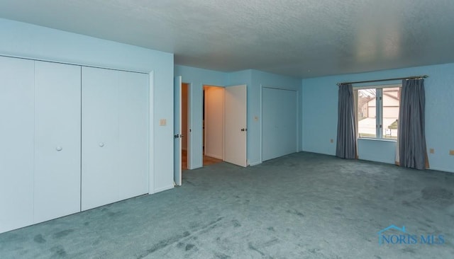 unfurnished bedroom with a textured ceiling and carpet floors