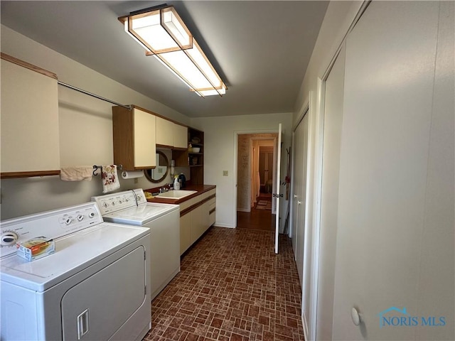 washroom featuring washer and clothes dryer, cabinets, and sink