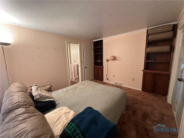 bedroom with a textured ceiling and dark carpet