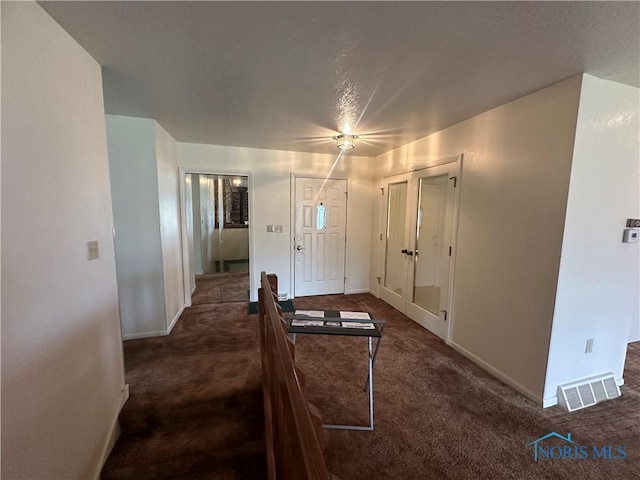 entryway featuring dark carpet