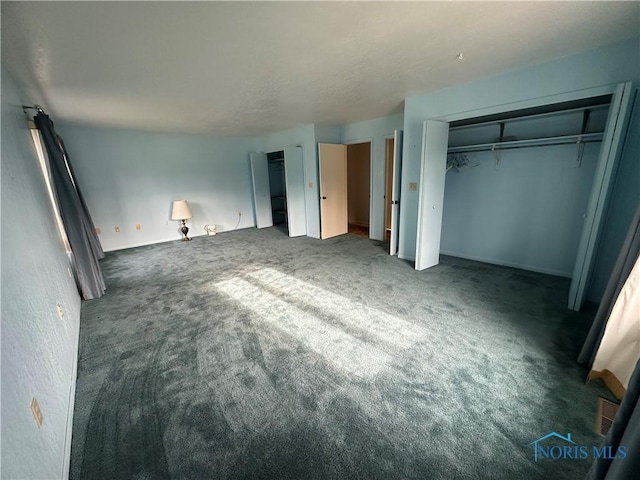 unfurnished bedroom with dark colored carpet