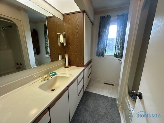 bathroom with tile patterned floors, vanity, toilet, and ornamental molding