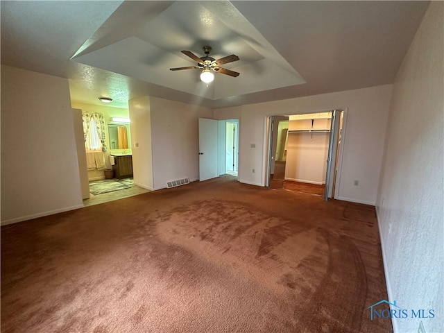 interior space featuring a tray ceiling and ceiling fan