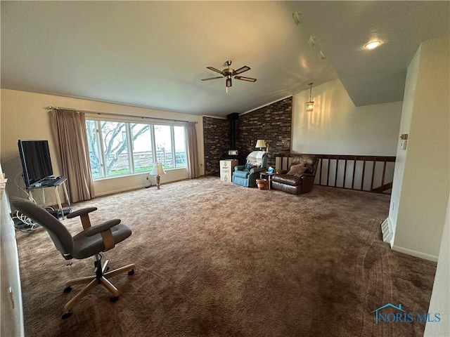 interior space featuring a wood stove, ceiling fan, carpet, and lofted ceiling