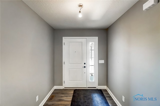 entryway featuring hardwood / wood-style flooring and a textured ceiling