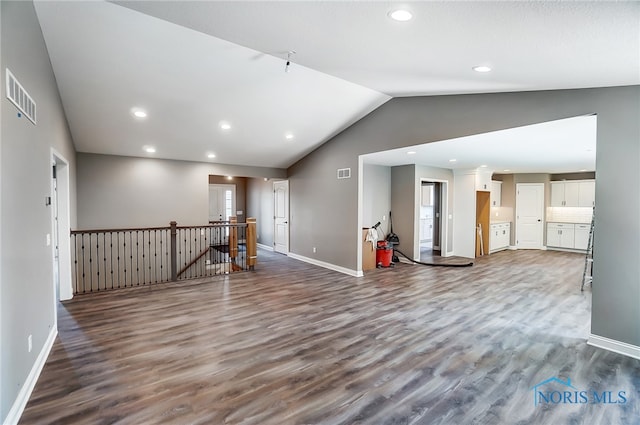 unfurnished living room with wood-type flooring and vaulted ceiling