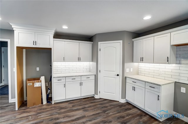 kitchen with white cabinetry, light stone countertops, tasteful backsplash, and dark hardwood / wood-style flooring