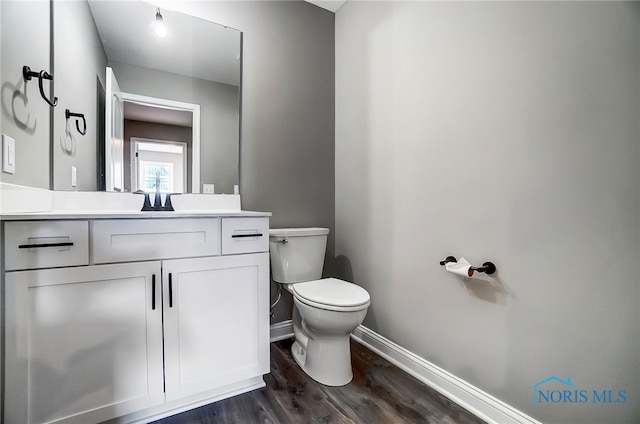 bathroom with vanity, toilet, and wood-type flooring