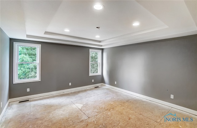 unfurnished room with a tray ceiling