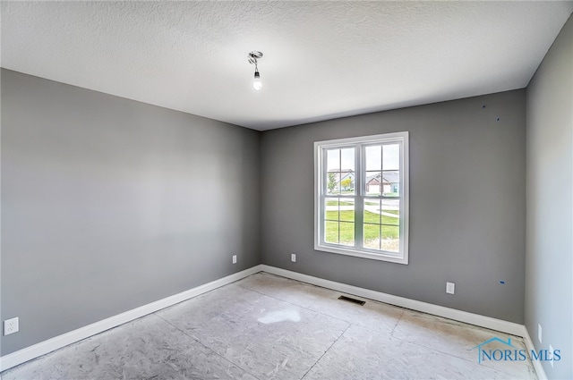 spare room featuring a textured ceiling