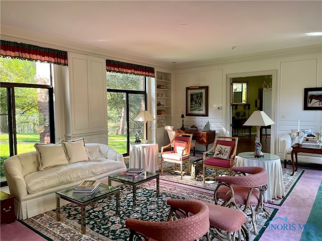 living room featuring crown molding, built in shelves, and a wealth of natural light