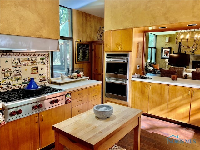 kitchen with hardwood / wood-style flooring, a notable chandelier, and appliances with stainless steel finishes