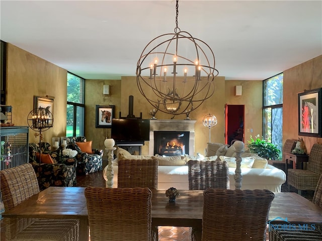 dining area featuring a chandelier and a fireplace