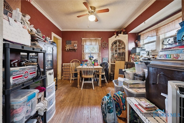 interior space featuring a textured ceiling, crown molding, ceiling fan, and light wood-type flooring