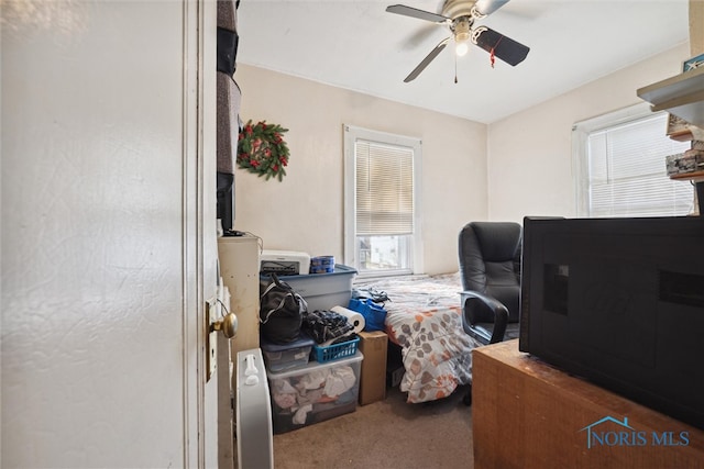 carpeted home office featuring ceiling fan