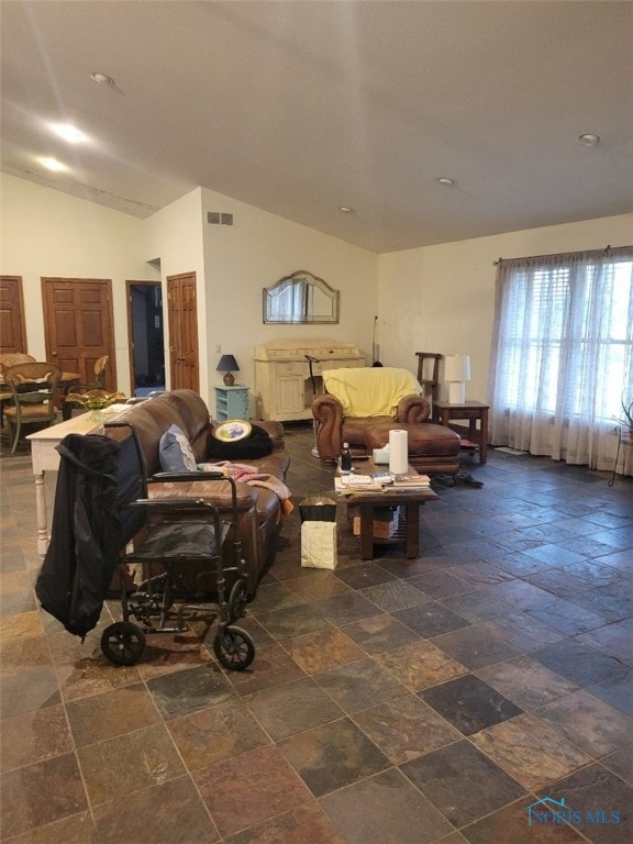 living room with dark tile flooring and lofted ceiling