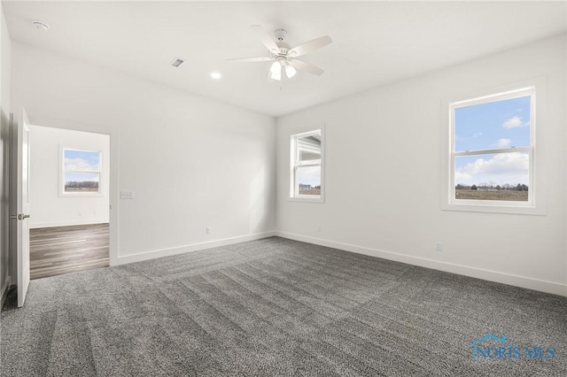 unfurnished room featuring dark carpet and ceiling fan