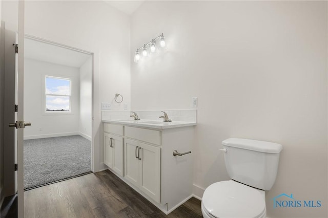 bathroom featuring vanity, hardwood / wood-style flooring, and toilet