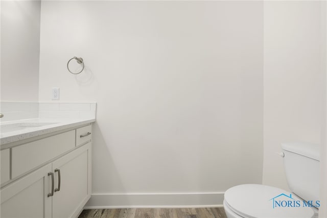 bathroom featuring vanity, hardwood / wood-style floors, and toilet