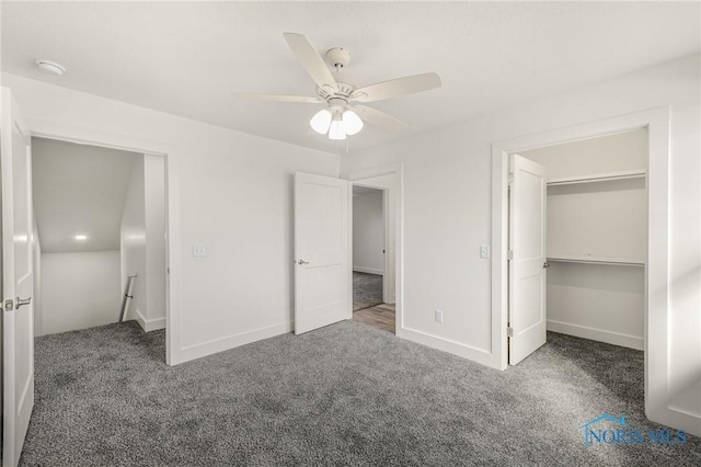 unfurnished bedroom with dark carpet, a closet, ceiling fan, and a spacious closet