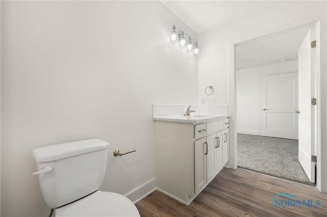 bathroom with vanity, toilet, and wood-type flooring