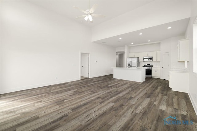 unfurnished living room with ceiling fan, high vaulted ceiling, and dark hardwood / wood-style flooring