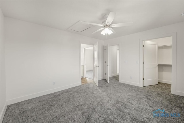 unfurnished bedroom featuring a walk in closet, carpet, and ceiling fan