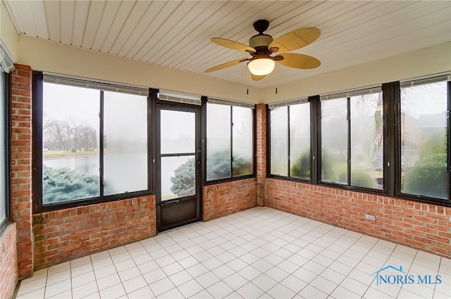 unfurnished sunroom featuring plenty of natural light, a water view, and ceiling fan