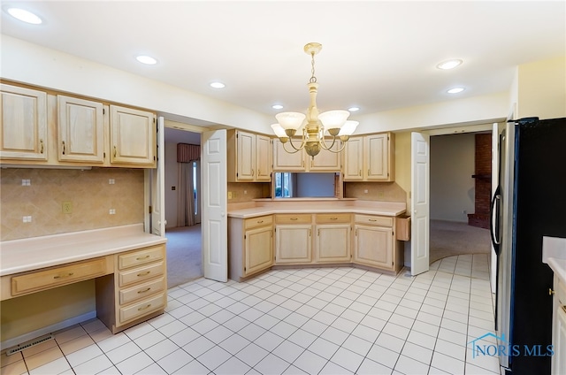 kitchen with light brown cabinets, stainless steel fridge, decorative light fixtures, and a chandelier