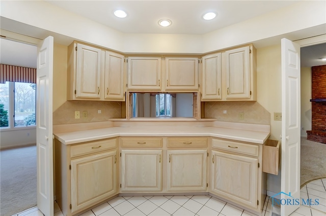 kitchen featuring light brown cabinetry, light tile flooring, and tasteful backsplash