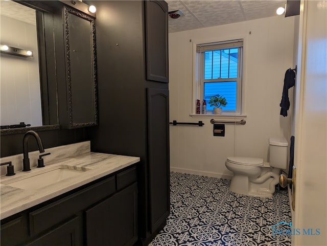 bathroom with tile patterned floors, vanity, a paneled ceiling, and toilet