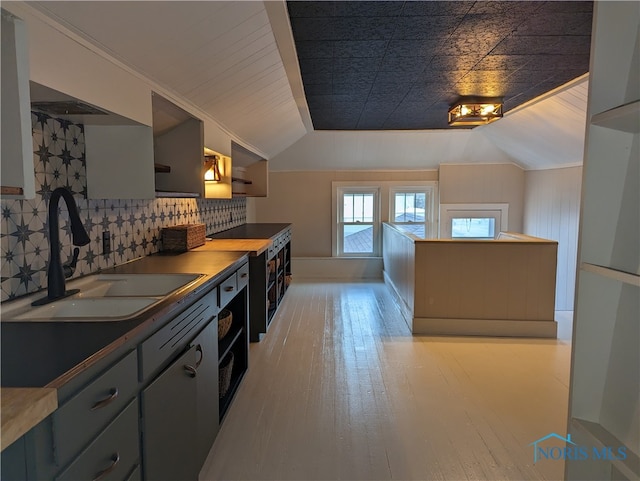 kitchen featuring light hardwood / wood-style floors, ornamental molding, sink, and gray cabinetry