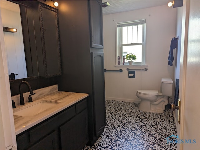 bathroom with vanity, toilet, and tile patterned flooring